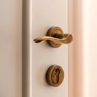 This City on Rose door lever features a neo-classical touch with its timeless curves and understated sophistication. The unlacquered burnished brass finish will develop a rich, unique patina over time, adding character and elegance.