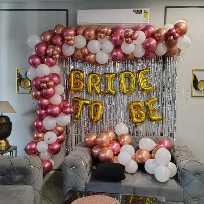 Our 'BRIDE TO BE' backdrops are a hit for bachelorette parties and bridal showers. This setup features a trendy rose gold and white balloon arch against a silver shimmer wall, creating the perfect spot for photos with the bride.