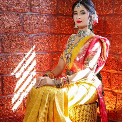 A beautiful bridal portrait session. The warm light hitting the laterite brick wall complements the yellow and red silk saree, creating a rich and timeless image.