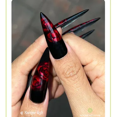 A close-up view of our stiletto nail extensions, featuring deep red roses hand-painted on a black base for a bold, romantic statement perfect for Valentine's Day.