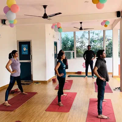 Students holding a standing pose during a class at our bright and airy Vikaspuri shala. The focus is on alignment and steady breathing.