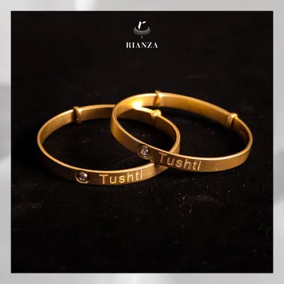 A perfect and magical gift for a little one. These custom gold bangles are engraved with the child's name, "Tushti," and feature a small bezel-set diamond.