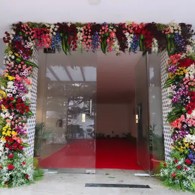 I create a grand and welcoming entrance for corporate office openings, like this full floral arch and red carpet setup for Trans cosmos. This design ensures your guests feel valued from the moment they arrive.