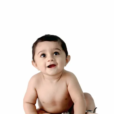 A simple and beautiful portrait of a happy baby sitting against a clean white background, with a joyful and innocent expression.