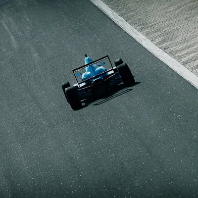 An aerial shot of our driver in a bright blue F1600 car, navigating the track at Kari Motor Speedway.