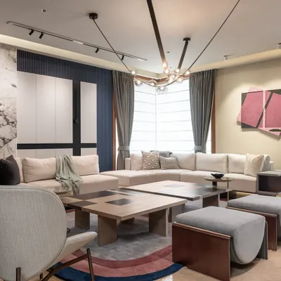 In this modern loft living area, we mixed a variety of materials to create a sophisticated feel. The space features a split central table, a colorful rug, and a striking marble wall panel, all working together to create a modern, luxurious ambiance.