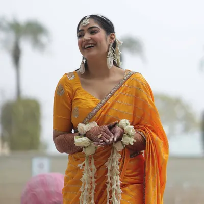 A candid laugh during my Haldi. I chose a simple, lightweight yellow saree so I could be comfortable and enjoy the day. The look was completed with fresh floral bracelets and statement earrings.