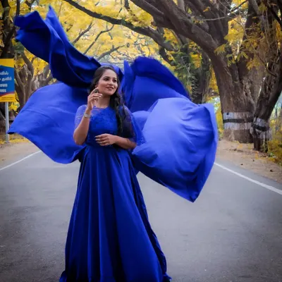 This royal blue gown with its large, detachable wings creates a powerful and elegant statement, perfect for an outdoor maternity photoshoot.