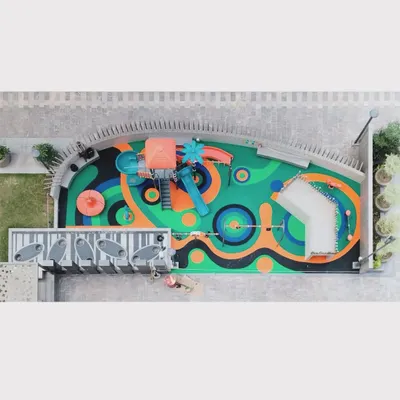 An aerial 'drone' view of the 'Pixelscapes' playground. The colorful and abstract EPDM rubber flooring is a key feature, turning the ground itself into a canvas for play and imagination.