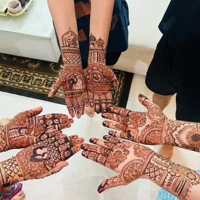 A lovely group shot of mehendi for the whole family. Each person has a unique design, from portraits to traditional patterns, reflecting their personal style.