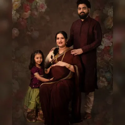A fine art maternity portrait celebrating a growing family. We created this traditional, painterly look in our studio, complete with elegant attire and a classic backdrop to honor this special time before the new baby arrives.