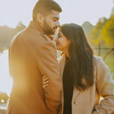 A couple shares an intimate moment, backlit by the golden hour sun during their pre-wedding shoot in Delhi. We use natural light to create warm, romantic couple portraits.