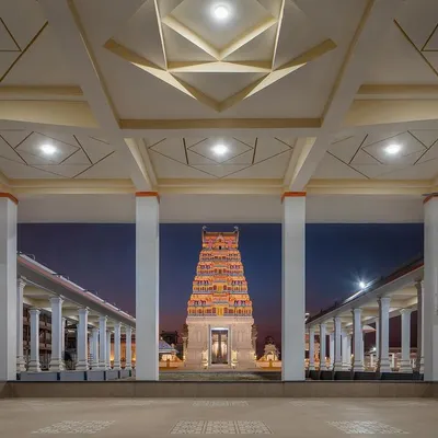 The main temple, lit up at night, stands as a beacon of faith and architectural beauty. The design respects Dravidian temple architecture while using modern construction and lighting techniques.