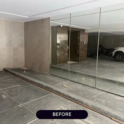 The "Before" shot of a parking-level entryway in Punjabi Bagh. This plain, empty planter box is the blank canvas for our transformation.