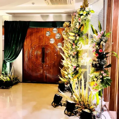 A stunning entrance to a Sangeet night, featuring a massive floral installation with a neon sign, setting a glamorous and exciting tone for the evening.