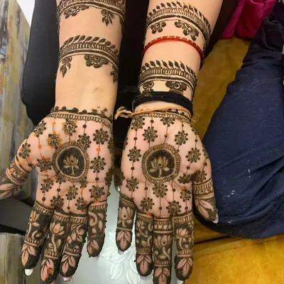 A balanced and symmetrical design featuring a lotus mandala on the palm. This style of intricate henna art provides full coverage while maintaining a feeling of elegance and order.
