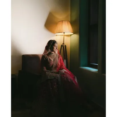A bride's quiet contemplation in the soft glow of a lamp before her Nikah ceremony. This moody, fine-art portrait captures the soulful anticipation and elegance of the moment, turning a fleeting feeling into a timeless piece of art.
