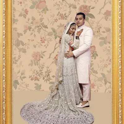 This portrait captures a truly special moment. I designed this intricate silver embroidered lehenga with a long, dramatic trail for the bride, and a coordinated blush pink sherwani for the groom, creating a picture of pure elegance.