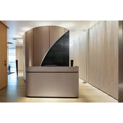 To solve a contrived entry at the Fineline Infra office, we introduced a curved wall to guide movement and add a 'wow' factor. The reception desk is minimalist, allowing the architectural form to stand out.