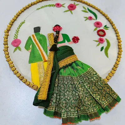 A beautiful hoop embroidery depicting a South Indian couple in traditional wedding attire. The bride's saree is made from real fabric, giving the piece a wonderful 3D effect.
