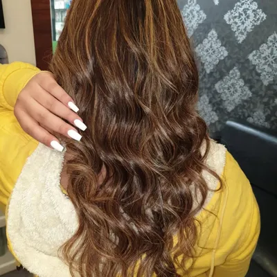 This client received a full head of highlights to add brightness and dimension to her long hair. The final look is styled into soft waves to showcase the blend of colors and the hair's healthy condition.