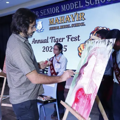 This is the live painting experience in action at the Mahavir Senior Model School's Tiger Fest. I work on an easel with oil paints, allowing guests to watch the creative process unfold in real time, making it an engaging spectacle for any event.