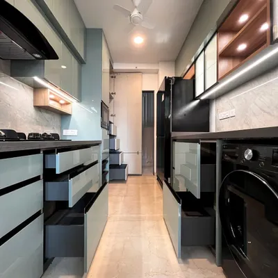 This galley kitchen is designed for maximum storage. On both sides, deep drawers and integrated units house everything from appliances to groceries, demonstrating how we optimize long, narrow spaces for complete functionality.