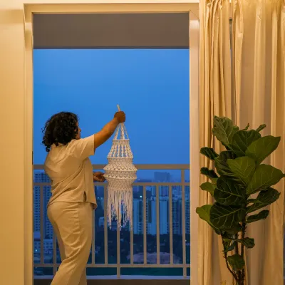 Here I am, placing the final touches. This moment, transitioning from the warm glow of the interior to the cool tones of the evening cityscape, is where you see the harmony come together. It's about balancing the curated design with the natural beauty outside.
