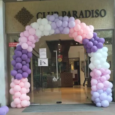 A beautiful pastel balloon arch welcomes guests to Club Paradiso for a butterfly-themed event. The blend of purple, pink, and white balloons creates a soft and dreamy entrance for a magical celebration.