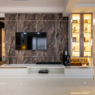 A luxurious TV unit featuring a marble-finish back panel with rose gold inlays. The design includes a sleek white console and a glass display cabinet, creating a stunning focal point in the living room.