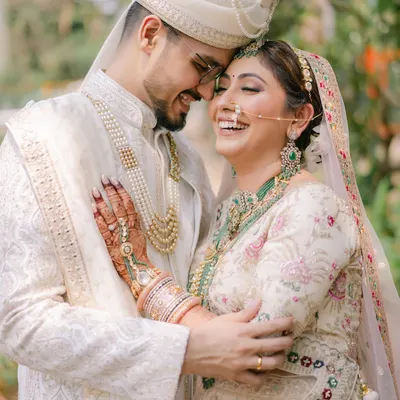That laugh says it all! A candid moment of pure joy between the bride and groom. Her makeup is soft and natural, designed to last through all the happy tears and laughter of the day.