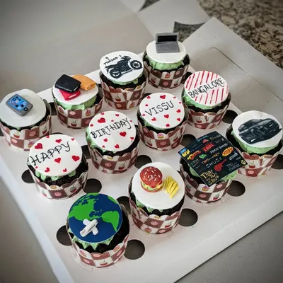 A full set of customized cupcakes, each with a unique, handcrafted topper. Themes here include travel, food, movies, and cars, showing the wide range of personalization possible.