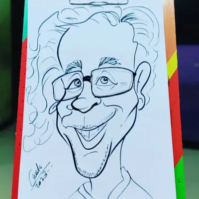 This is a finished caricature of a man with curly hair and glasses, signed and ready. It’s a great example of the final product you can learn to create.