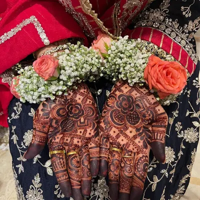 The beautiful, dark stain of a bridal henna, perfectly complemented by the bride's floral hand jewelry. This is the result of natural henna and proper aftercare.