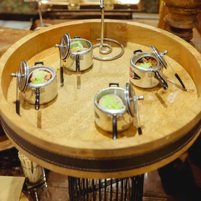 My signature mini pressure cookers used for serving individual portions of Indian dishes. This unique presentation adds a quirky and memorable touch to the dining experience.