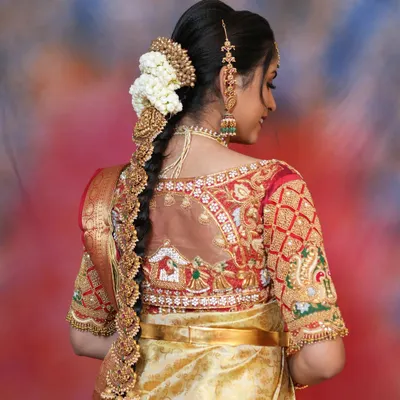 A beautiful back view of a bride's hairstyle, adorned with a traditional temple-style jade bille. This is a must-have hair accessory for a classic South Indian bridal look.