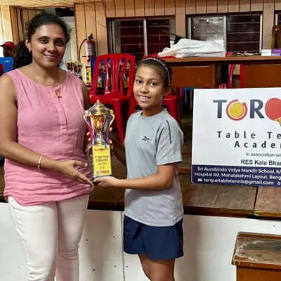 Anaya, at just 9 years old, holding her first-place trophy after winning the U11 Girls Tournament at the Torque Table Tennis league.