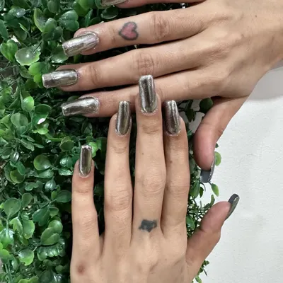 A full set of silver chrome nails on squared extensions. This style is incredibly popular for its bold, mirror-like finish that stands out in any setting. It's a clean yet powerful look.