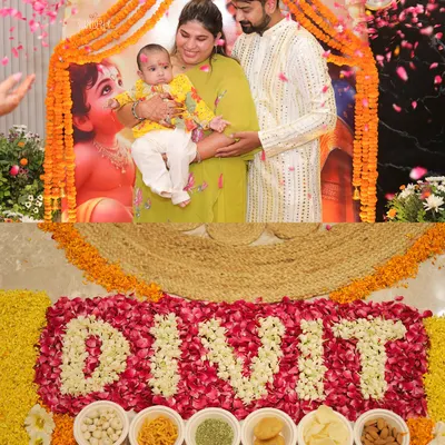 A beautiful moment from baby Divit's Annaprashan ceremony. The family gathers for a photo in front of the Krishna-Yashoda backdrop, with his name written in flowers, marking his first meal.