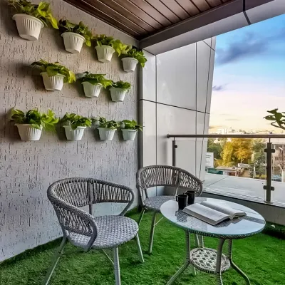 A simple yet charming balcony makeover featuring comfortable wicker chairs and an artificial grass floor. The wall-mounted planters create a vertical garden, adding life and color without taking up precious floor space.