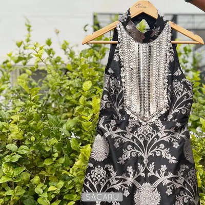 A statement halter-neck top crafted from black and silver brocade. The focal point is the heavily hand-embroidered yoke, which adds a touch of glamour, making it a perfect piece for a sangeet or cocktail event.
