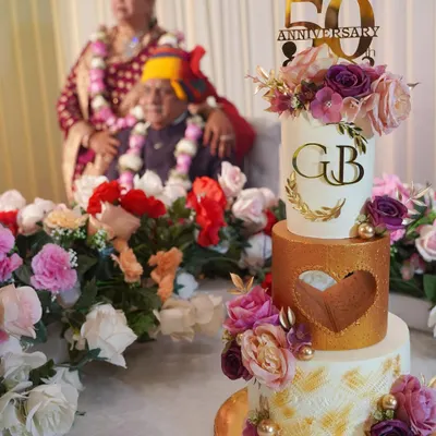 A cake as timeless as their love. This three-tier white and gold cake, adorned with delicate flowers, was for my parents' 50th anniversary. Every detail was a tribute to their beautiful journey together.