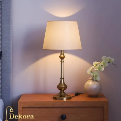 Our classic brass table lamp offers timeless elegance for any surface. The beautifully turned base and simple fabric shade create a warm, welcoming light, ideal for a traditional bedroom or a sophisticated study.