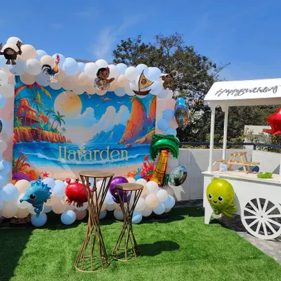 An outdoor Moana-themed party on a terrace with artificial grass. The setup is bright and perfect for a daytime celebration.