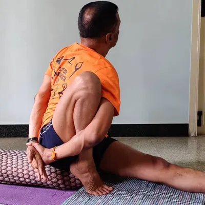 Marichyasana 1. A seated forward bend and twist that targets the spine and abdominal organs. The bolster provides height, making the forward extension more accessible.
