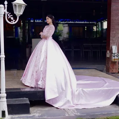A full view of this magnificent pink ball gown, showcasing its impressive trail. This gown is crafted from lustrous satin with delicate embroidery, ensuring a grand and dramatic entrance for any bride at her reception.