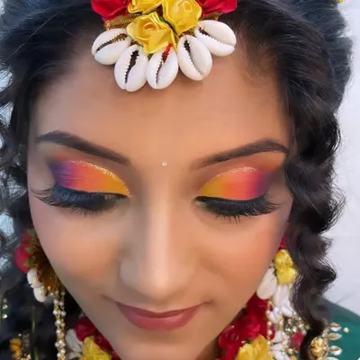 A close-up of a vibrant Haldi eye makeup look, featuring a sunset-inspired blend of yellow, orange, and pink. This is perfect for the colorful and joyous Haldi ceremony.