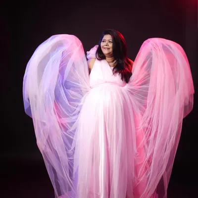 This is the ultimate glam shot. I use dramatic lighting and the flowing fabric of this pink rental gown to create a breathtaking, angelic portrait for expecting mothers.