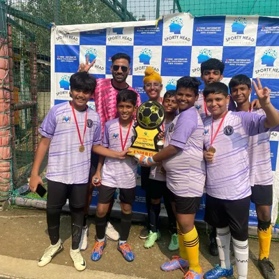 Pure joy and teamwork. Our U15 squad celebrates their championship win at the Sportyhead Premier League in Malad, holding the trophy high.