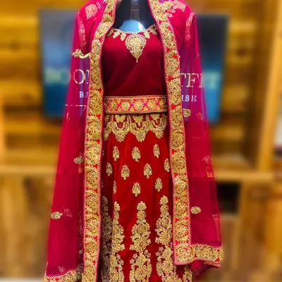 This is my classic red velvet bridal lehenga, available for rent. It features extensive gold embroidery across the skirt and blouse, making it a perfect statement piece for a traditional wedding ceremony.
